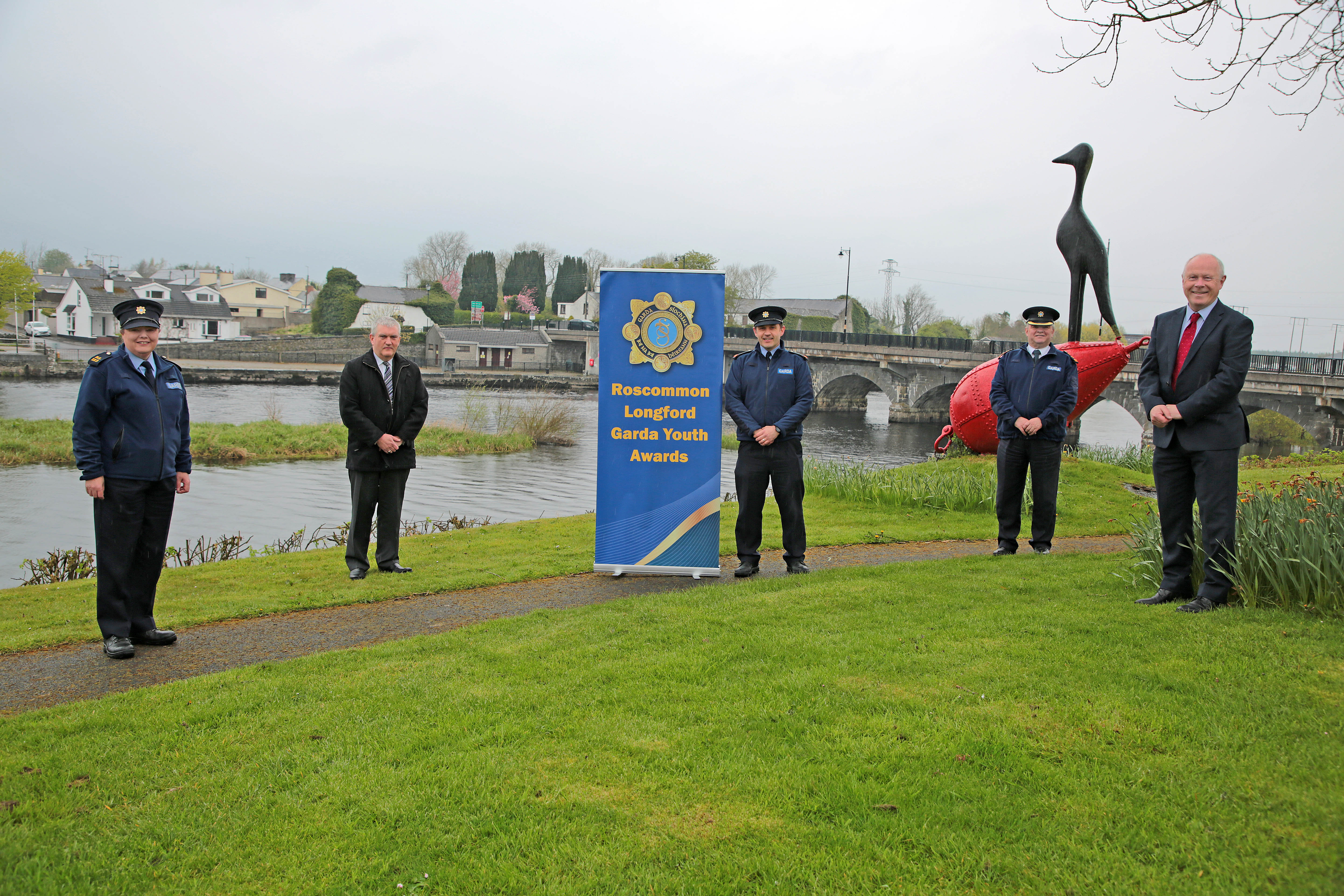 Standing on the banks of the River Shannon with the bridge at Lanesboro/Ballyleague in the background to promote the Roscommon-Longford Garda Youth Awards are: Coordinator of the Roscommon-Longford Garda Youth Awards Garda Angela Mullooly; Chief Executive Roscommon County Council Eugene Cummins; Chairman of Roscommon-Longford Garda Youth Awards Inspector David Cryan; Roscommon-Longford Garda Division Chief Superintendent Tony Healy and Chief Executive Longford County Council Paddy Mahon. 