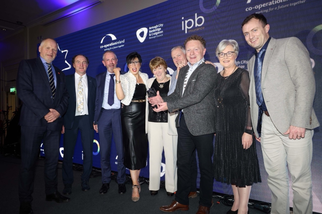 Group of eight people standing for a photograph with their award